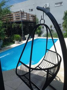 un columpio frente a una piscina en Tres Chihuahuas & Spa en Mariano Moreno