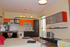 a living room with a kitchen with orange cabinets at Alghero Budget Automated check in in Alghero
