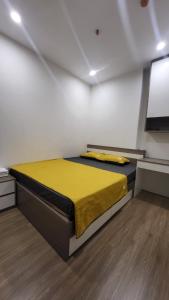 a bedroom with a yellow bed in a room at Meii House - Vinhome Ocean Park S201 in Hanoi