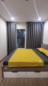 a bedroom with a bed with a yellow blanket at Meii House - Vinhome Ocean Park S201 in Hanoi