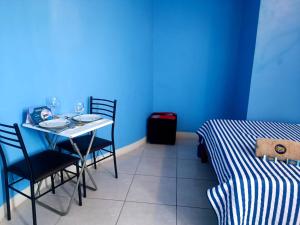 um quarto azul com uma mesa e cadeiras e uma cama em CASA COMPARTIDA em Chiclayo