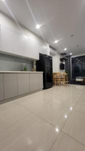 a kitchen with white cabinets and a black refrigerator at Meii House - Vinhome Ocean Park S201 in Hanoi