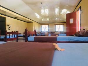 a room with three beds and two windows at Korovou Eco Lodge in Naviti Island