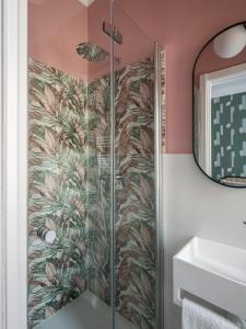 y baño con ducha y papel pintado tropical. en Mini suite di design, en Milán