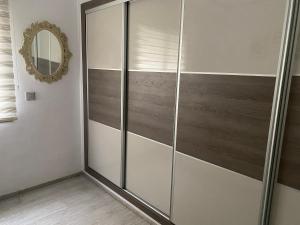 - une porte de douche en verre dans une chambre avec un miroir dans l'établissement Luxe à petit prix, à Salambôo