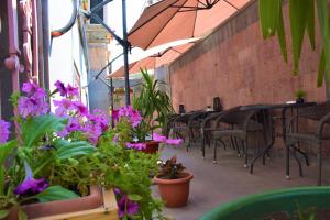 a patio with tables and chairs and purple flowers at Mia Casa Hotel Yerevan in Yerevan