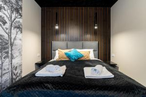 a bedroom with a bed with two towels on it at Apartament Widokowe Marzenie - blisko stoku, parking podziemny by SpaceApart in Karpacz +35 photos
