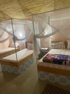 two twin beds in a bedroom with at Hotel Toolbi in Niaga