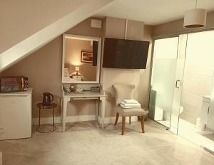 Zimmer mit einem Tisch, einem Stuhl und einem Spiegel in der Unterkunft White Quarry House in Navan