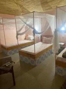 two bunk beds in a room with a table at Hotel Toolbi in Niaga