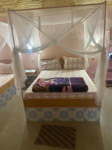 a bed with a canopy in a room at Hotel Toolbi in Niaga