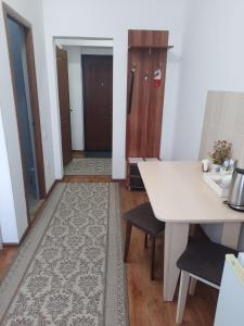 a room with a table and chairs and a hallway at Апарт отель Welcome in Taldykorgan