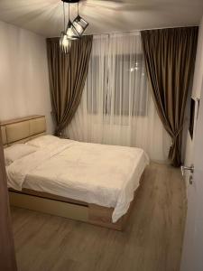 Un dormitorio con una cama y una ventana con cortinas. en Dream 1, en Bucarest