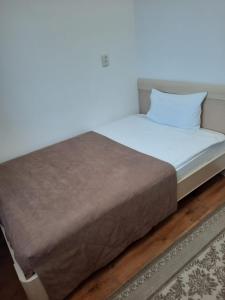 un letto con lenzuola e cuscini bianchi in una stanza di Апарт отель Welcome a Taldykorgan