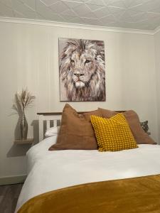 a bedroom with a bed with a painting of a lion at The Chroma Cottage in Cock Hill