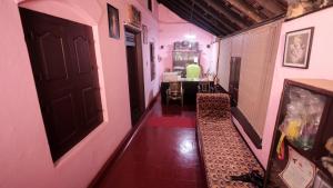 um corredor com um quarto com paredes cor-de-rosa e uma porta em CAFFEE ISLAND FARM VILLA em Kaniyāmbetta