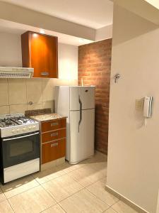a kitchen with a white refrigerator and a stove at Complejo Pampa 1 in Santa Rosa