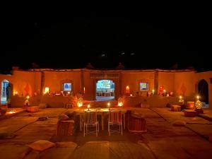 a patio with a table and chairs at night at Camp Desert Bivouac Chegaga in El Gouera