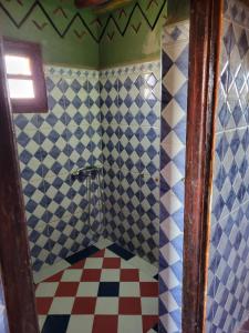 a bathroom with a shower with blue and white tiles at Camp Desert Bivouac Chegaga in El Gouera
