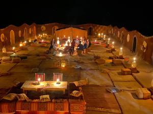 un grupo de personas de pie en una calle por la noche en Camp Desert Bivouac Chegaga, en El Gouera