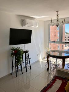 sala de estar con TV de pantalla plana y mesa en ALOHA Güemes Premium, 1 dorm Clásico y Moderno en Córdoba