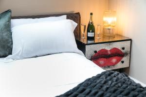 - une chambre avec un lit et une table de chevet avec des verres à vin dans l'établissement The Sky Lodge & Penthouse Apartments at Hillthorpe Manor by Maison Parfaite - Wentbridge, à East Hardwick