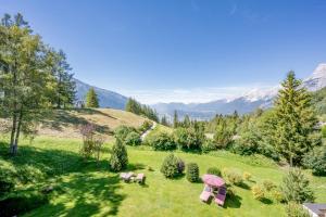 una vista aérea de un césped con mesas de picnic y montañas en Inntaler Hof en Seefeld in Tirol