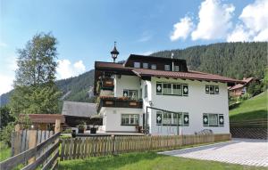 a large white house with a wooden fence at Awesome Apartment In Schladming With 1 Bedrooms And Internet in Schladming