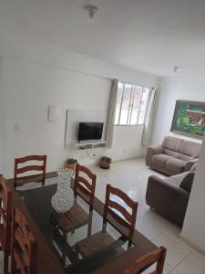 uma sala de estar com uma mesa e cadeiras e um sofá em Antonia Haddad em Lorena