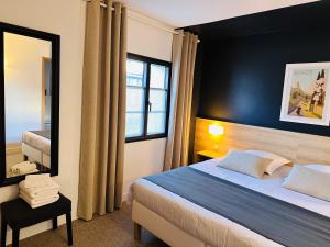 - une chambre avec un grand lit et un miroir dans l'établissement Appartements 3 étoiles terrasse ou patio intra-muros, à Aigues-Mortes