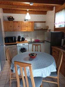 eine Küche mit einem Tisch und einer Schüssel darauf in der Unterkunft Chaleureux gîte des brocards aux pieds des sapins 3 étoiles in Allarmont