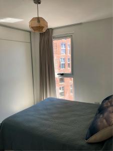 Un dormitorio con una cama grande y una ventana en ALOHA Güemes Premium, 1 dorm Clásico y Moderno en Córdoba