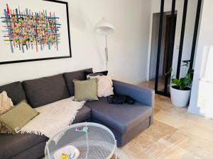 - un salon avec un canapé et un ventilateur dans l'établissement Appartements 3 étoiles terrasse ou patio intra-muros, à Aigues-Mortes