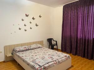 - une chambre avec un lit aux papillons sur le mur dans l'établissement Sunset Villa, à Costinesti