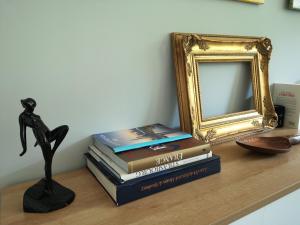 a shelf with a stack of books and a mirror at Bel Appartement avec jardin privé au calme in Strasbourg