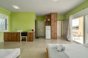 a living room with green walls and a kitchen at Piperitsa house for nomads or families in the countryside in Messini
