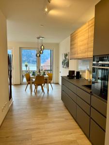 a kitchen with a table and a dining room at Ferienwohnung mit Seeblick - Ossiacher See Gerlitzen in Sattendorf