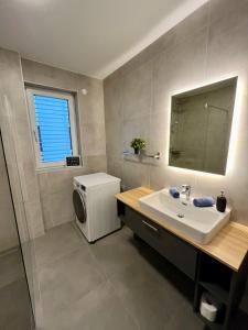 La salle de bains est pourvue d'un lavabo et d'un lave-linge. dans l'établissement Ferienwohnung mit Seeblick - Ossiacher See Gerlitzen, à Sattendorf