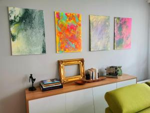 a shelf with a mirror and some paintings on a wall at Bel Appartement avec jardin privé au calme in Strasbourg