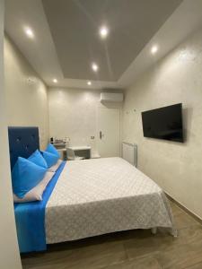 ein Schlafzimmer mit einem großen Bett und einem Flachbild-TV in der Unterkunft Domus Cinecittà in Rom