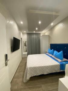 a bedroom with a large bed with blue pillows at Domus Cinecittà in Rome