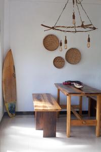 uma mesa e um banco numa sala com uma prancha de surf em Marshmallow Homestay em Ahangama