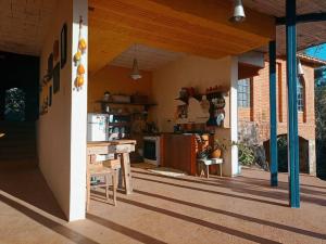 a kitchen with a table and a counter in a house at Casa rústica cercada de natureza em Atibaia in Atibaia