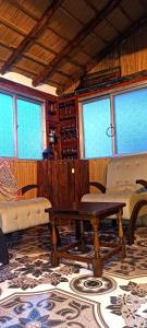a living room with a table and chairs and windows at Los diablitos in Punta Del Diablo