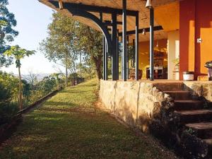 a building with stairs next to a grass field at Casa rústica cercada de natureza em Atibaia in Atibaia