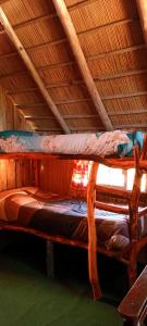 a bunk bed in a room with a roof at Los diablitos in Punta Del Diablo +84 photos