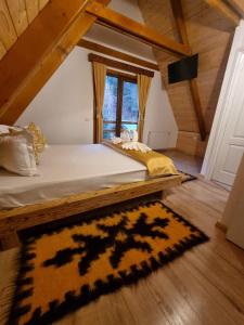 um quarto com uma cama, um tapete e uma janela em Casuta Armonia em Moisei
