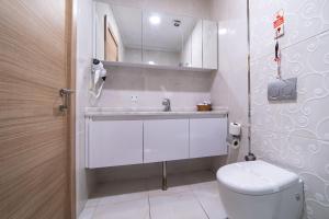 a white bathroom with a toilet and a sink at Mardy Hotel in Istanbul