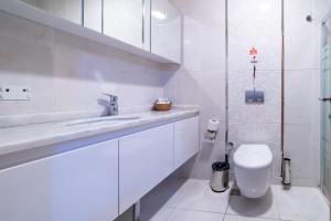 a white bathroom with a toilet and a sink at Mardy Hotel in Istanbul