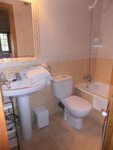 uma casa de banho com um lavatório, um WC e uma banheira em Al Llagar em Colunga